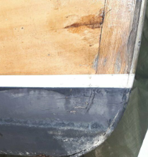 Die Leiste muss neu verschraubt werden und die Beschädigung unten ausgebessert werden; Außerdem das Holz am Überwasserschiff vorne